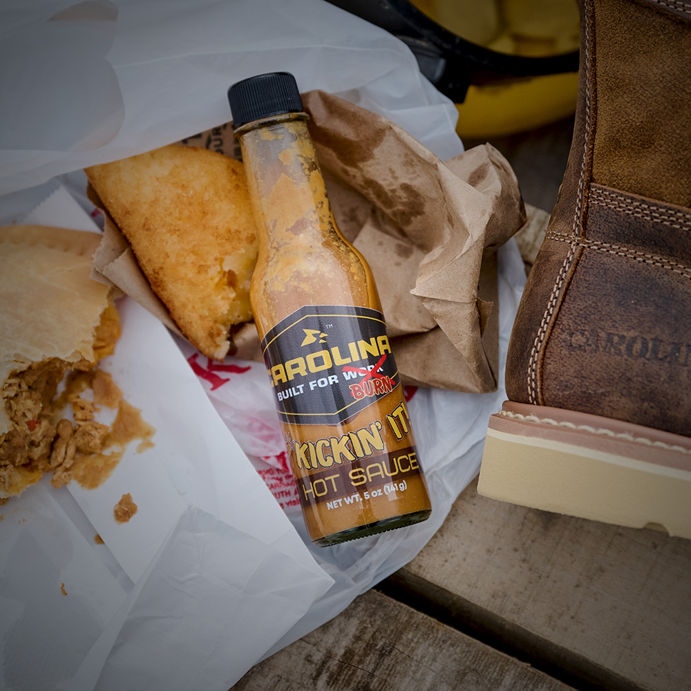 Carolina Hot Sauce with food next to a Carolina boot in brown.